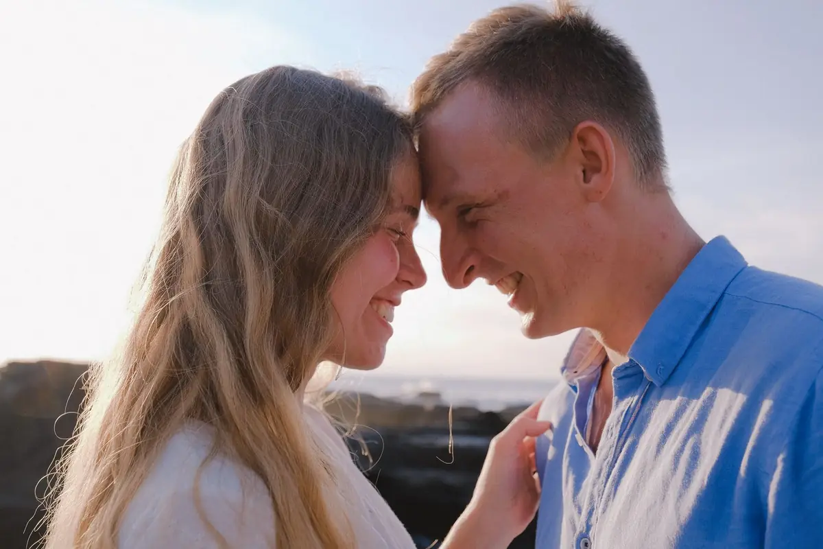Pareja feliz sonriendo frente a frente al aire libre